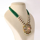 Featuring a handcrafted pendant with layered polki and diamond detailing, accented by rose quartz, emeralds, and rubies, paired with emerald bead strings and South Sea pearls for a regal finish. (GDNE0515)