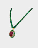 A captivating pendant featuring a ruby cabochon encircled by emerald-cut ovals and diamonds, strung with emerald beads for a bold fusion of colour, brilliance, and timeless luxury. (GDPE0408)