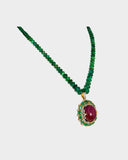 A captivating pendant featuring a ruby cabochon encircled by emerald-cut ovals and diamonds, strung with emerald beads for a bold fusion of colour, brilliance, and timeless luxury. (GDPE0408)