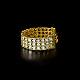 Versatile gold choker cum bracelet adorned with shimmering round diamonds, uncut diamond polki, and vibrant oval emerald accents, crafted in layered elegance to create a bold, luxurious statement for contemporary and traditional looks. (KMBR0150)