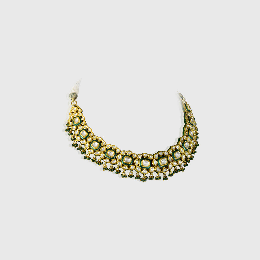 Elevate your elegance with this exquisite green Meena necklace and earring set, adorned with uncut diamonds. A timeless fusion of traditional artistry and luxury, perfect for weddings and grand celebrations.(KMNE3525)