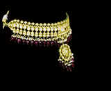 This white choker necklace and jhoomki pair is beautifully crafted with uncut diamonds, and strung with rubies and pearls. A perfect blend of elegance and tradition for weddings and festive occasions.(KMNE3585)