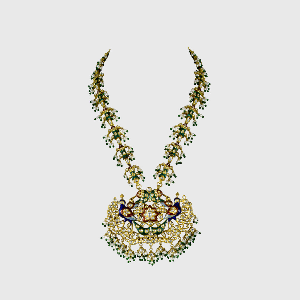 Celebrate tradition with this vibrant multi-color enameled long necklace and earring pair, adorned with uncut diamonds and pearls. Featuring intricate fish design links and a majestic peacock pendant. (KMNE3605)