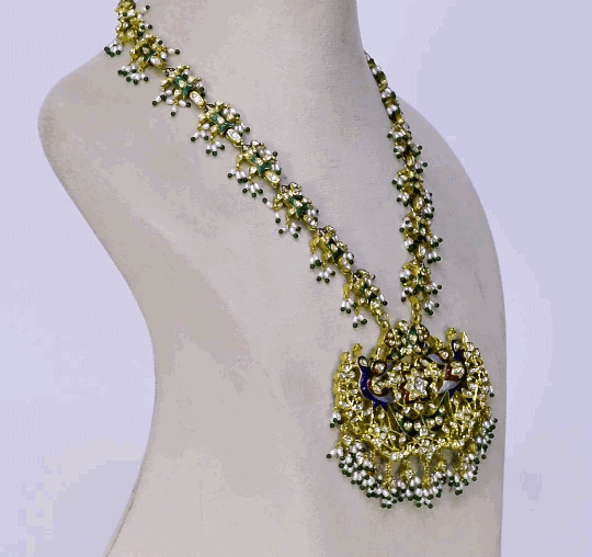 Celebrate tradition with this vibrant multi-color enameled long necklace and earring pair, adorned with uncut diamonds and pearls. Featuring intricate fish design links and a majestic peacock pendant. (KMNE3605)