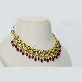 A striking necklace and earring set adorned with diamond polki and rich ruby stones, strung with ruby maniya and pearls. A timeless expression of heritage artistry and refined luxury, perfect for festive and celebratory moments. (KMNE3637)