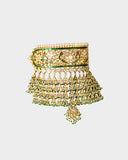 A traditional Rajasthani aad necklace and earring set crafted with diamond polki, accented by rich green stones and pearl stringing. An opulent expression of royal heritage and timeless bridal elegance. (KMNE3663)