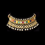 A vibrant Navratan choker in gold, adorned with polki diamonds and nine gemstones, finished with cascading pearl fringes, paired with statement earrings for a rich, traditional, and festive look. (KMNE3705)