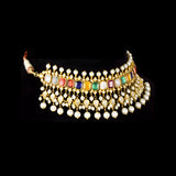 A vibrant Navratan choker in gold, adorned with polki diamonds and nine gemstones, finished with cascading pearl fringes, paired with statement earrings for a rich, traditional, and festive look. (KMNE3705)