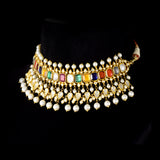 A vibrant Navratan choker in gold, adorned with polki diamonds and nine gemstones, finished with cascading pearl fringes, paired with statement earrings for a rich, traditional, and festive look. (KMNE3705)