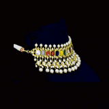 A vibrant Navratan choker in gold, adorned with polki diamonds and nine gemstones, finished with cascading pearl fringes, paired with statement earrings for a rich, traditional, and festive look. (KMNE3705)