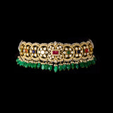 A fusion Navratan choker featuring polki diamonds in gold, highlighted with a central ruby, multicolored gemstones, intricate pearl detailing, and cascading emerald drops—paired with statement earrings for a rich, regal presence. (KMNE3719)