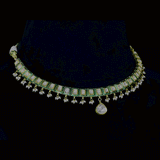 A refined single-line gold necklace set featuring polki diamonds with green enamel detailing, accented by delicate pearl hangings, paired with matching earrings—perfectly blending traditional elegance with understated, modern sophistication. (KMNE3722)