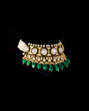 A majestic choker showcasing large polki diamonds set in striking green-enamelled gold, layered with intricate detailing, finished with cascading emerald drops and pearl fringes—opulent, bold, and exquisitely regal. (KMNE3724)