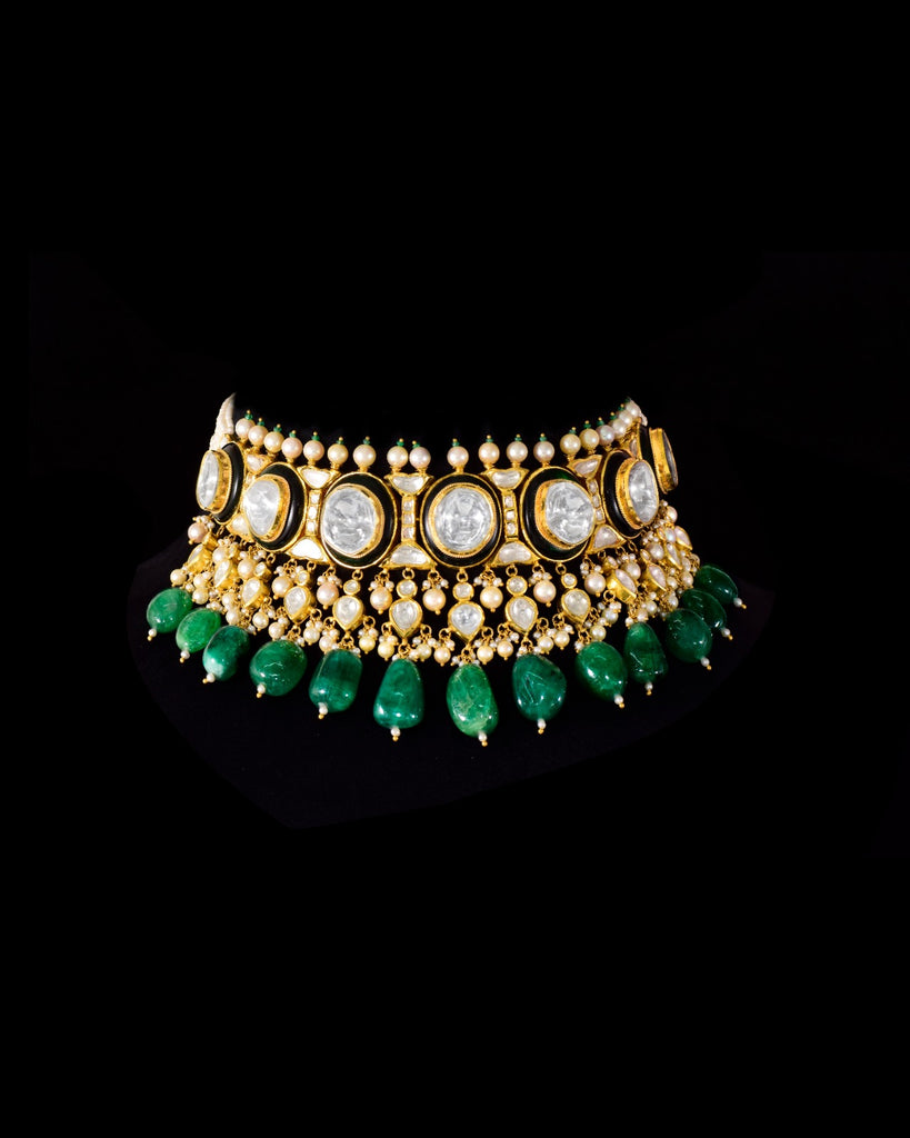 A majestic choker showcasing large polki diamonds set in striking green-enamelled gold, layered with intricate detailing, finished with cascading emerald drops and pearl fringes—opulent, bold, and exquisitely regal. (KMNE3724)