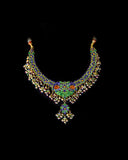 Grand statement necklace and earring pair featuring intricate peacock meenakari in vibrant hues, adorned with uncut diamond polki, highlighted by cascading multicolor beads with pearls, reflecting regal artistry and timeless bridal elegance. (KMNE3743)