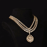 A masterpiece of traditional craftsmanship, this three-line Polki necklace with pendant and earrings radiates enduring elegance and royal charm.(KMNE3785)