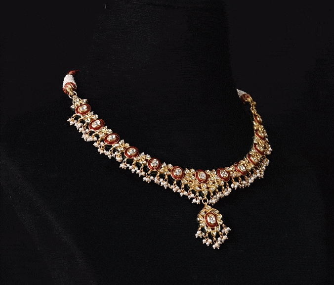 Grace every celebration with this handcrafted red meenakari necklace and earrings, featuring natural Polki diamonds and pearl accents.(KMNE3790)