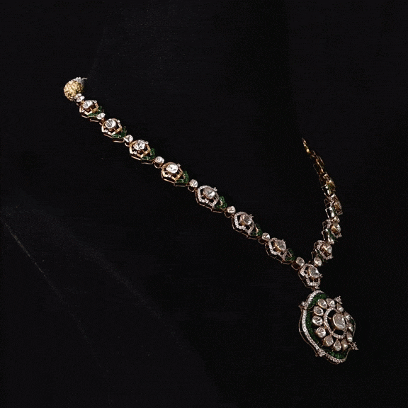 A striking fusion of heritage and modern glamour, this Polki diamond necklace set shines with brilliant diamonds and elegant green stones.(KMNE3791)