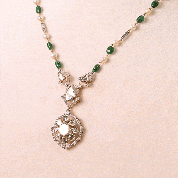 Grace your celebrations with this exquisite Diamond Polki necklace and earrings, accented with brilliant diamonds, emerald maniya, and delicate pearls.(KMNE3792)