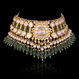 Handcrafted to perfection, this Diamond Polki choker and earrings blend classic artistry with elegant emerald drops and pearl accents.(KMNE3797)