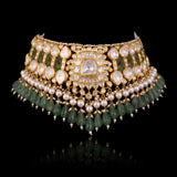 Handcrafted to perfection, this Diamond Polki choker and earrings blend classic artistry with elegant emerald drops and pearl accents.(KMNE3797)