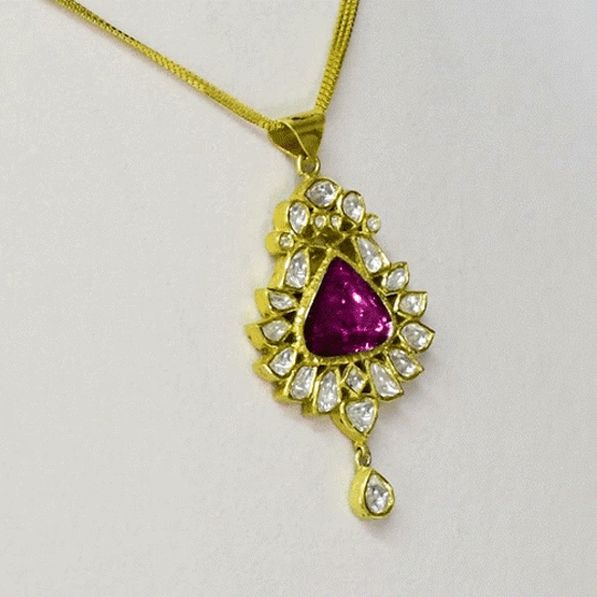 An elegant pendant featuring diamond polki with a striking central tourmaline, blending classic craftsmanship with vibrant colour for a timeless statement. (KMPE1353)