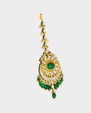 A regal maangtika adorned with diamond polki and a radiant emerald centre, finished with emerald and pearl stringing for timeless elegance and traditional bridal charm. (KMTK0243)