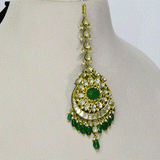 A regal maangtika adorned with diamond polki and a radiant emerald centre, finished with emerald and pearl stringing for timeless elegance and traditional bridal charm. (KMTK0243)