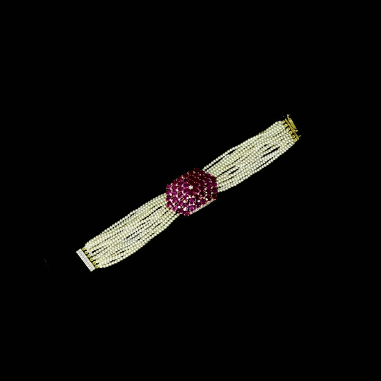 Delicate pearl strands come together with a sparkling ruby and diamond centerpiece, creating a graceful bracelet that blends classic beauty with modern elegance for every special occasion.(PGDBR074)