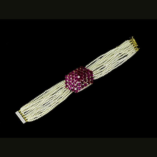 Delicate pearl strands come together with a sparkling ruby and diamond centerpiece, creating a graceful bracelet that blends classic beauty with modern elegance for every special occasion.(PGDBR074)
