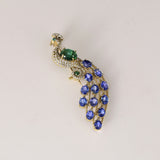 Royal Peacock Brooch Elegant peacock brooch adorned with vivid blue sapphires, rich emerald, and brilliant diamonds, beautifully capturing regal grace and timeless sophistication.(PGDBRCH002)