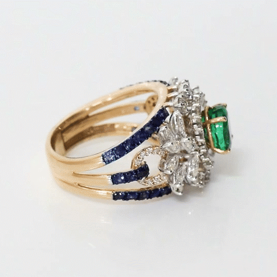 An elegant ring featuring emerald, sapphire, and diamonds, blending rich colour and brilliance for a sophisticated statement design. (PGDR0458)