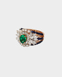 An elegant ring featuring emerald, sapphire, and diamonds, blending rich colour and brilliance for a sophisticated statement design. (PGDR0458)