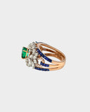 An elegant ring featuring emerald, sapphire, and diamonds, blending rich colour and brilliance for a sophisticated statement design. (PGDR0458)