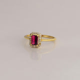 Celebrate timeless beauty with an emerald-cut pink tourmaline ring, gracefully highlighted by a shimmering halo of brilliant round diamonds.(PGDR0472)