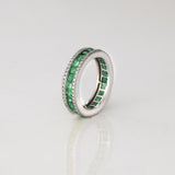 A timeless eternity band showcasing vivid channel-set emeralds, framed by brilliant round diamonds for an elegant statement of everlasting luxury.(PGDR0510)