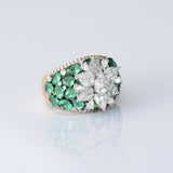 Featuring a sparkling diamond flower centerpiece surrounded by rich green emeralds, this ring is a true symbol of refined elegance. (PGDR0516)