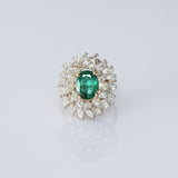 A vibrant emerald centerpiece surrounded by sparkling diamonds, creating a graceful ring filled with timeless elegance and charm.(PGDR0520)