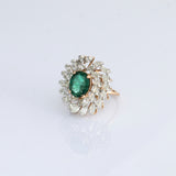 A vibrant emerald centerpiece surrounded by sparkling diamonds, creating a graceful ring filled with timeless elegance and charm.(PGDR0520)
