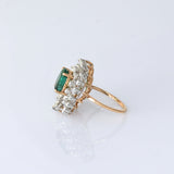 A vibrant emerald centerpiece surrounded by sparkling diamonds, creating a graceful ring filled with timeless elegance and charm.(PGDR0520)