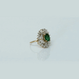 A vibrant emerald centerpiece surrounded by sparkling diamonds, creating a graceful ring filled with timeless elegance and charm.(PGDR0520)