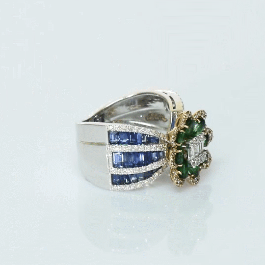 Featuring a diamond cluster center, encircled by vivid emeralds and accented with channel-set sapphires, this ring is designed to make a powerful statement. (PGDR0523)