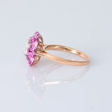 A radiant round diamond embraced by a halo of vivid pink sapphires—where timeless brilliance meets feminine charm. (PGDR0524)