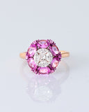 A radiant round diamond embraced by a halo of vivid pink sapphires—where timeless brilliance meets feminine charm. (PGDR0524)