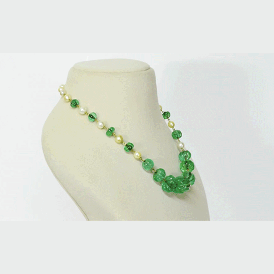 Exquisite carved Colombian emeralds paired with lustrous South Sea pearls, meticulously strung in gold wire to create refined timeless beauty.(STRG290)