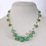 Exquisite carved Colombian emeralds paired with lustrous South Sea pearls, meticulously strung in gold wire to create refined timeless beauty.(STRG290)