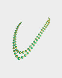 A luxurious double-line string of intricately carved emerald beads, delicately strung on gold wire, radiating timeless elegance and sophistication. (STRG348)
