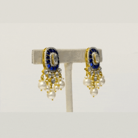 Our exquisite earrings, adorned with dazzling Diamond Polki, Diamond Rounds, and vibrant blue stones, accentuated by delicate pearl hangings. Embrace the fusion of elegance and sophistication (KME2255)