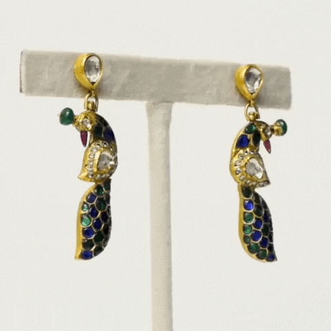 Discover the epitome of versatility and elegance with our reversible peacock design earring pair. Featuring exquisite diamond polki and vibrant colored stones, each side offers a unique expression of beauty inspired by the majestic peacock.(KME2141)