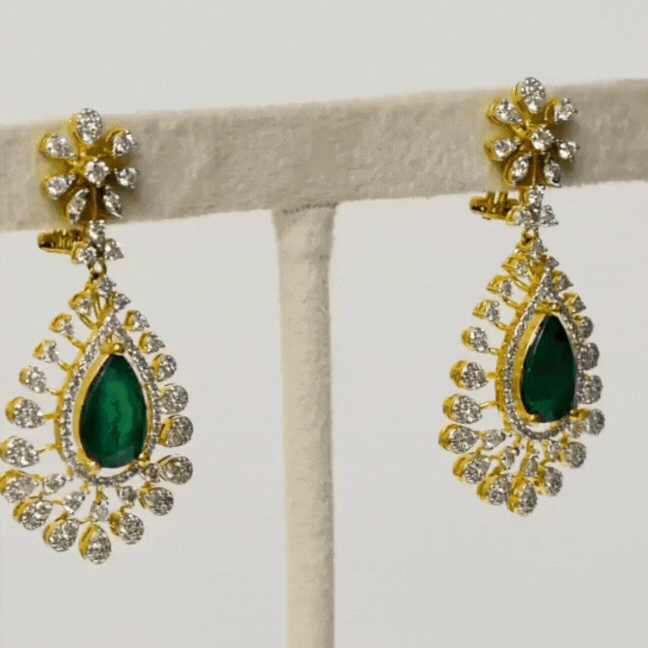Adorn yourself in elegance with our exquisite long earring pair, featuring pear-shaped emeralds delicately embraced by shimmering diamonds (PGDE0374)